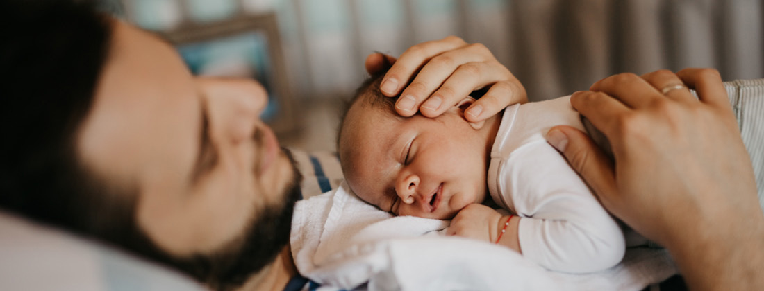 Baby sleeps on Dad's chest