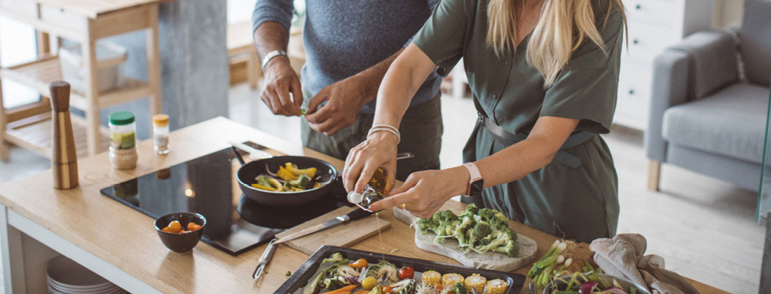 Man and woman cooking dinner at home - Ayurvedic eating