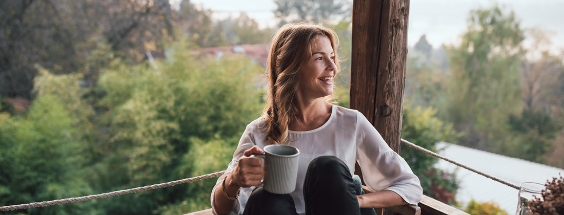 woman enjoying the outdoors with a hot drink