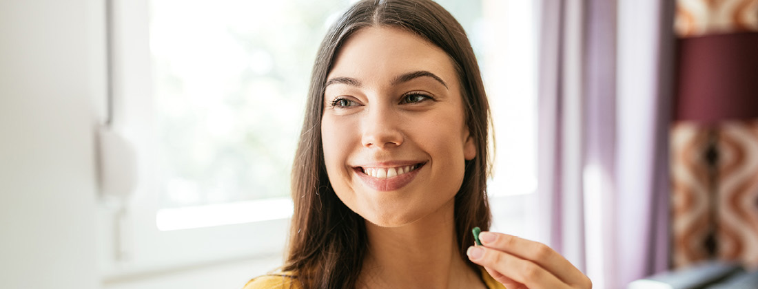 Woman smiling taking natural health supplement